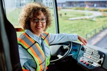 Conductrice de voyageurs à proximité d’un bus